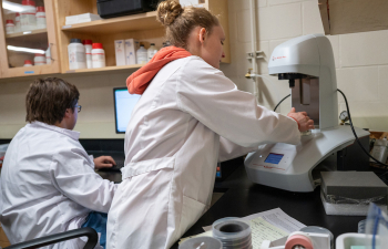 Two students conduct an experiment in a campus lab