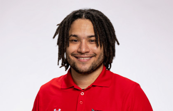 Headshot of Forrest Davidson, a young African American man with black twisted hair wearing a red polo shirt