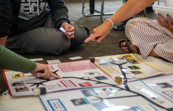 Adult learners work on a project using Montessori materials