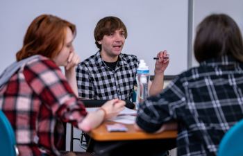male and female students engage in discussion during class