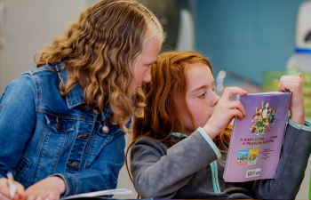 Two kindergarteners read during free time taught by a UWRF student teacher