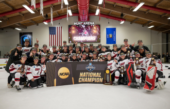 the women's hockey team poses with their trophy on the ice