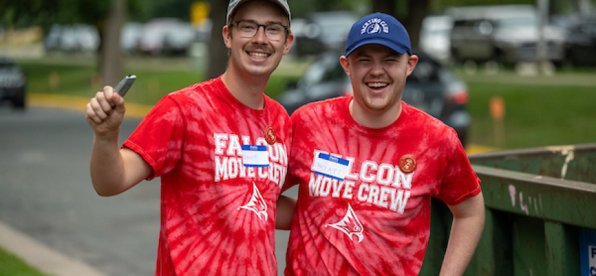 Two men posing while volunteering to maintain recycling